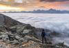 Hiker admires the sea of clouds from the Becca di Viou